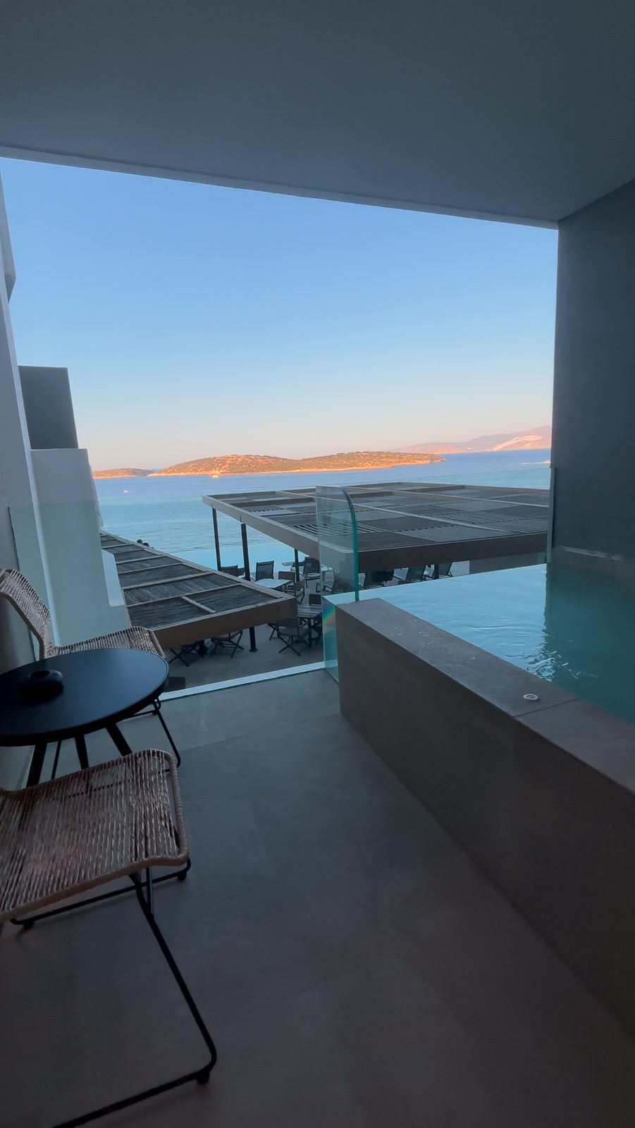 The balcony at golden hour, plunge pool first, then the infinity pool, then Mirabello Bay and the mountains doing the rest.