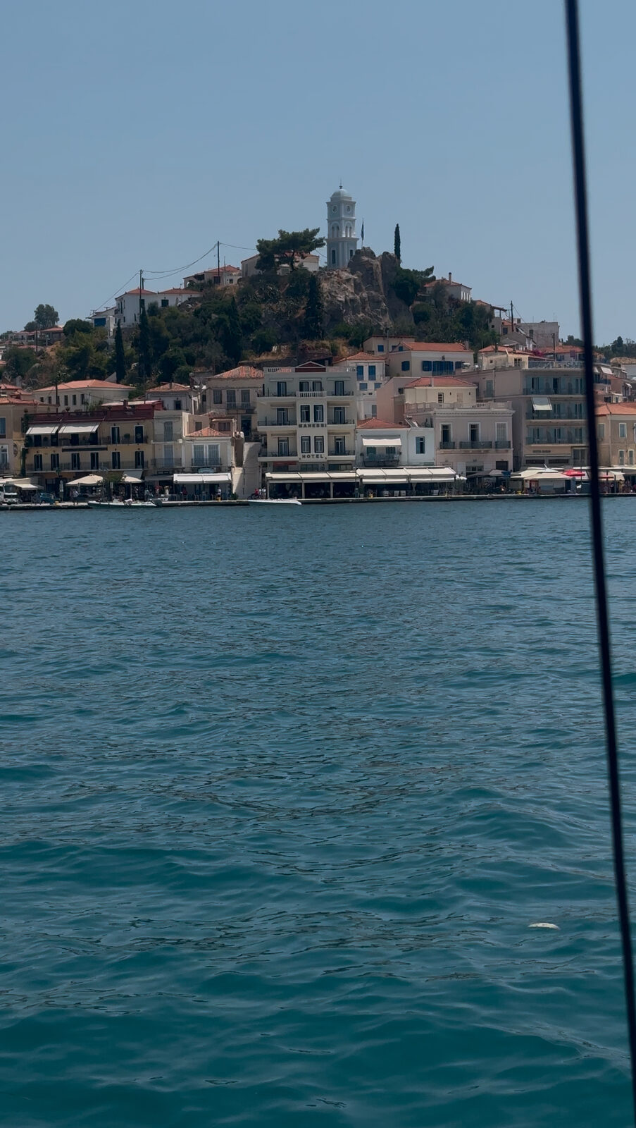 Poros town and its clock tower from the water, seen from our rental boat
